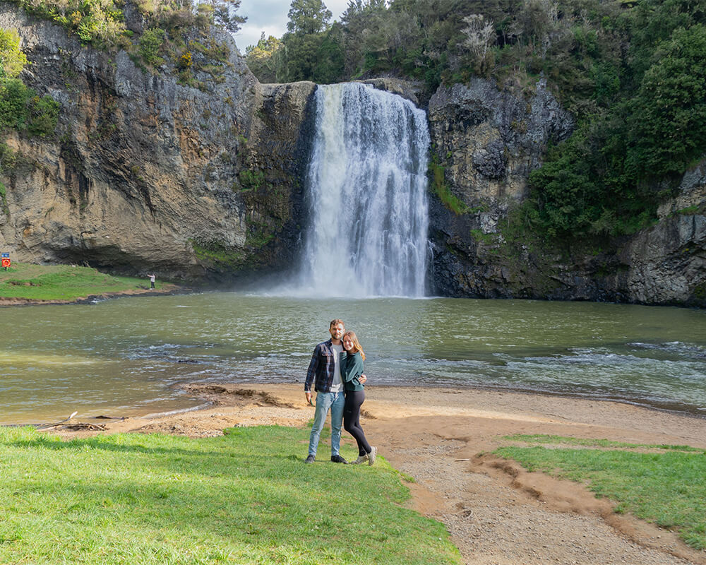 Junges Paar steht vor einem Wasserfall