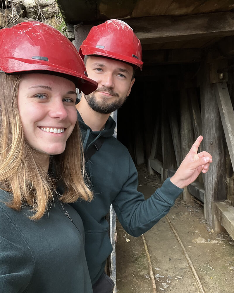 Selfie von einem Paar mir roten Helmen vor dem Eingang der Thames Goldmine