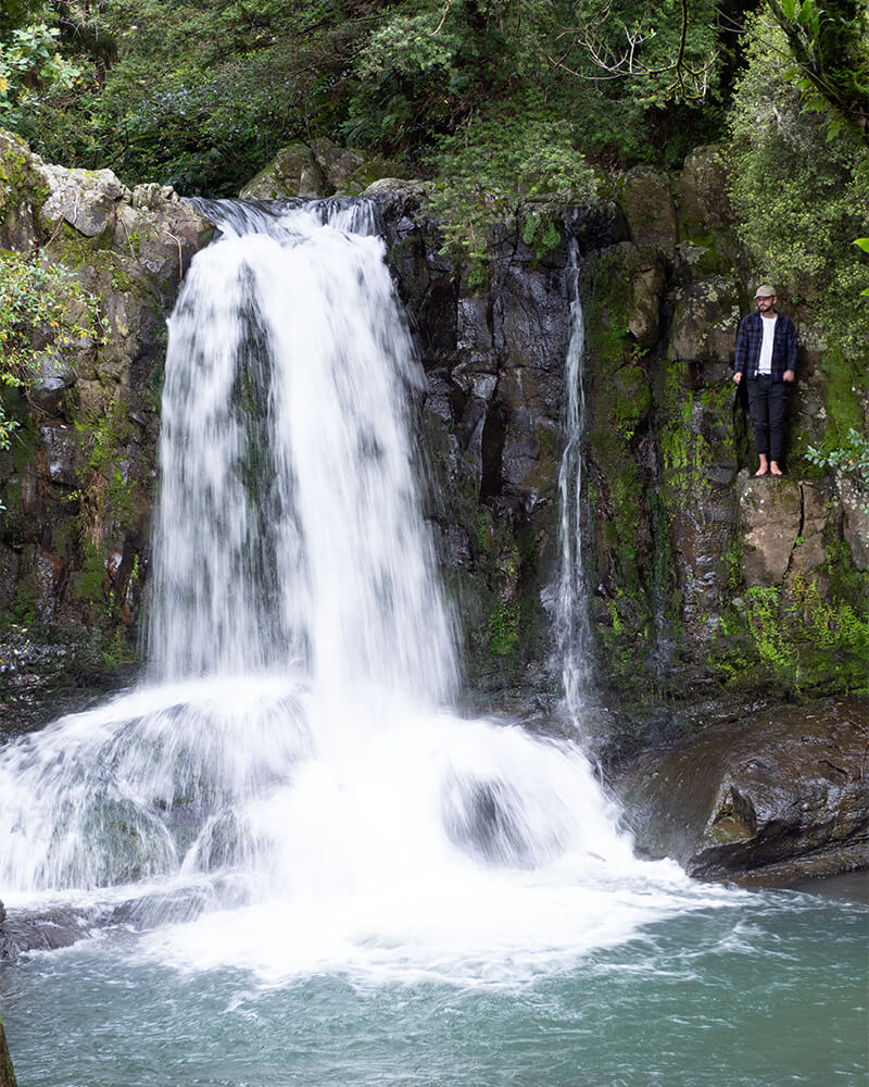 junger Mann steht neben den Waiau Waterfalls