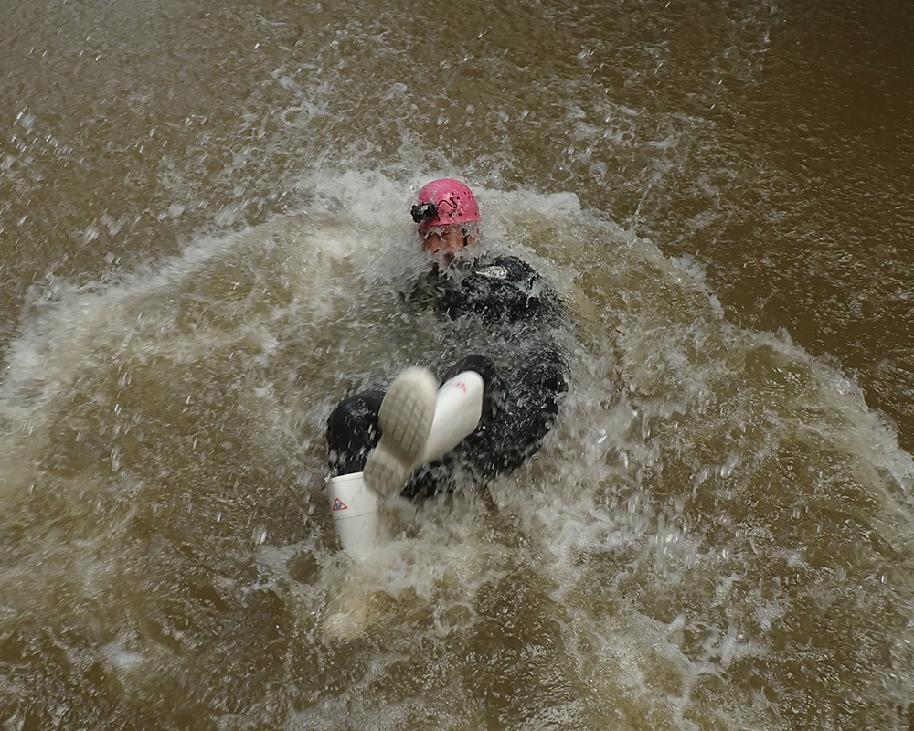 junger Mann in einem Reifen im Wasser