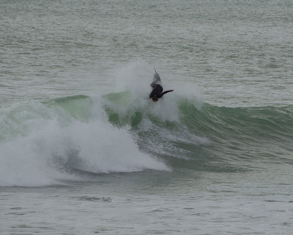 Surfer auf dem Meer macht einen Trick